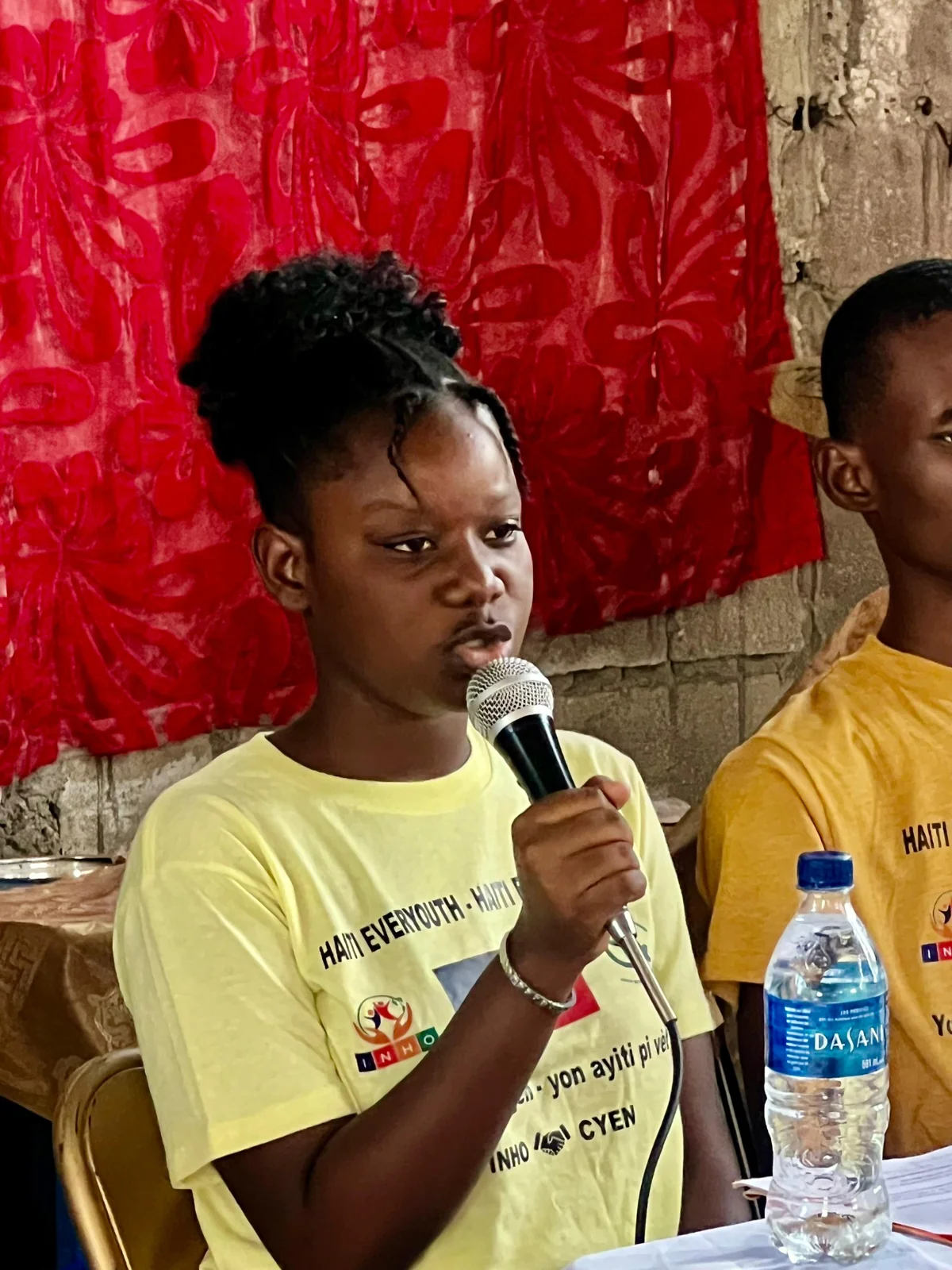 A child speaking into a microphone during a group activity